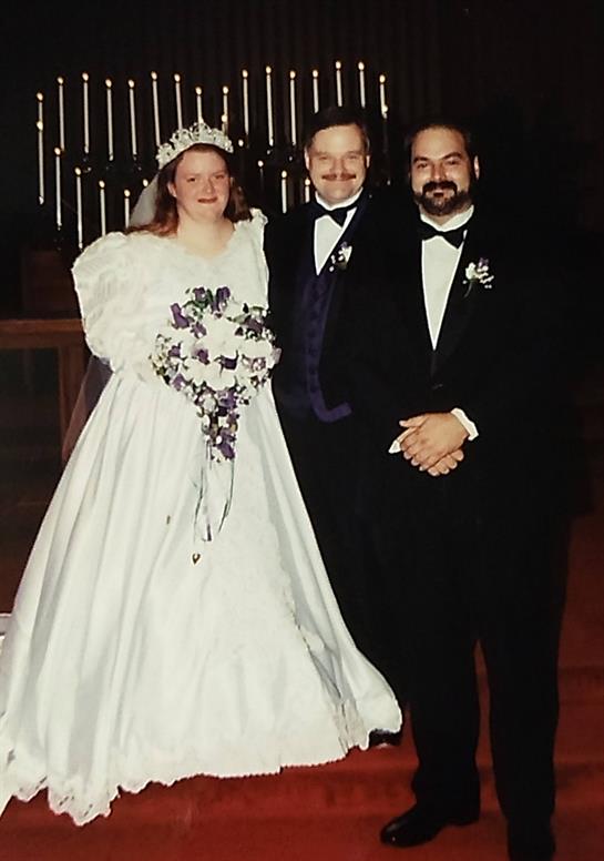 Wedding ceremony features bride in white gown and tuxedo-clad friends in a festive atmosphere.