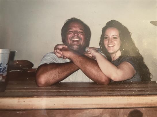 Two people share joyful moments at a bar, laughing and playfully interacting with each other.