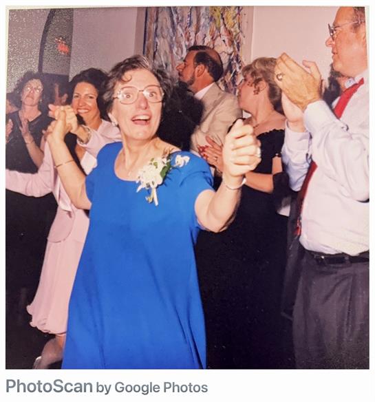 People gather for a vibrant celebration, dancing and clapping in a joyful atmosphere.