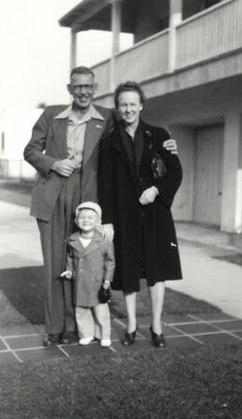 A man and woman standing together with a child