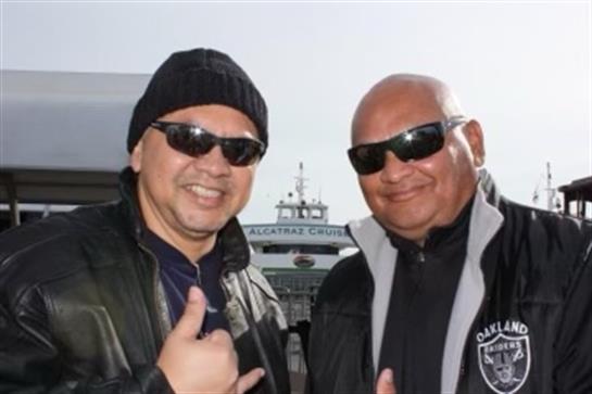 Two friends smile in sunglasses at the marina, enjoying a bright afternoon together.