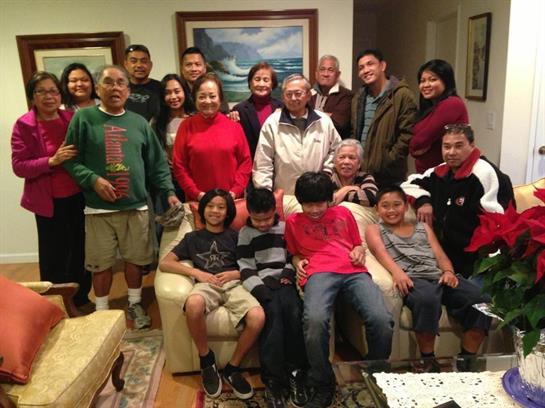 A large family joyfully celebrates together in festive attire, relishing each other's company.