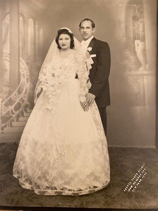 A couple in formal wedding attire exudes timeless elegance in a classic setting.