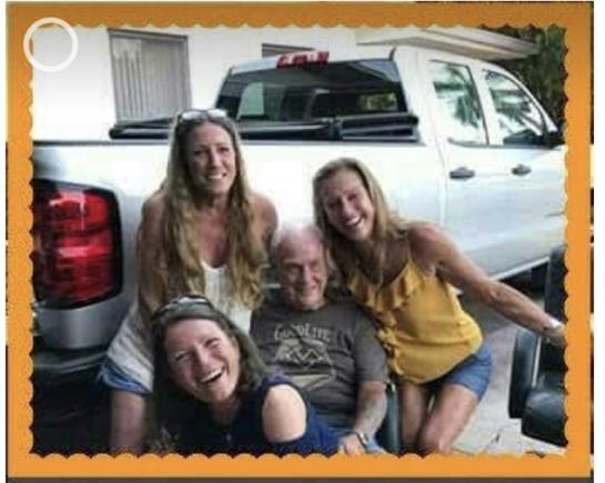 Four women and one man share joyful moments outdoors beside a parked truck, creating warm memories.