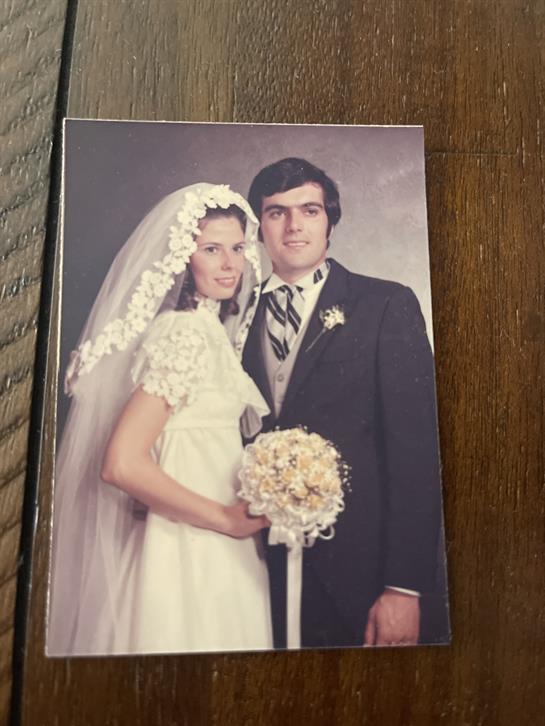 A picture of a man and woman in wedding attire