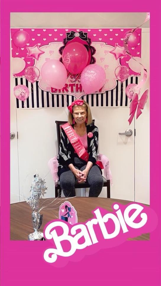 A woman sitting in a chair with a pink sash