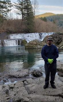 A man standing in front of a waterfall