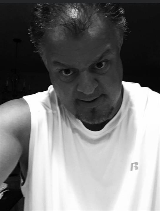 A man stares intently at the camera, highlighting his strong features and determination.