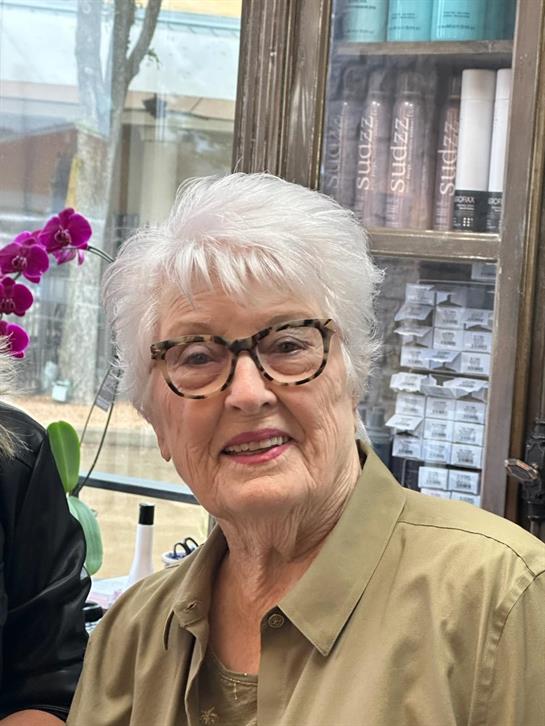 Senior woman smiles with her friend at the salon, celebrating a great hairstyling day.