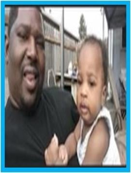 A father smiles as he holds his young child outdoors, enjoying a sunny day in a backyard.