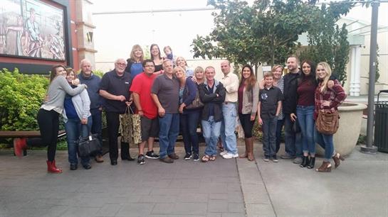 A large group smiles together outside for a joyful picture at the gathering.