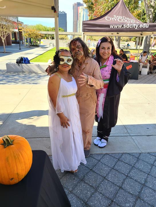 Friends in creative costumes enjoy an outdoor gathering during a festive celebration.