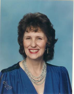 A woman wearing a blue dress and necklace