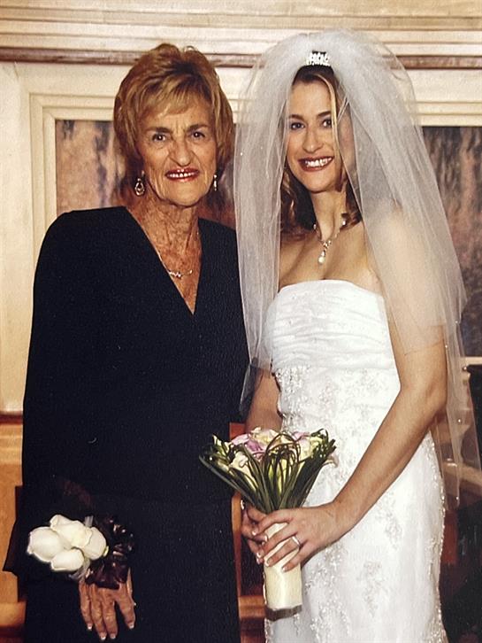 A joyful moment captured as the bride stands alongside her grandmother, both smiling warmly.