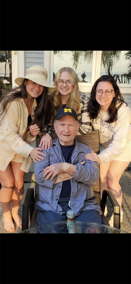 A group of women posing for a picture with a man in a chair