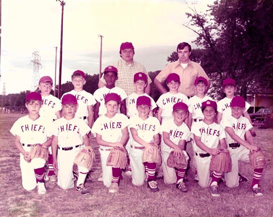 Young baseball players gather for a group picture, showcasing team spirit and camaraderie.