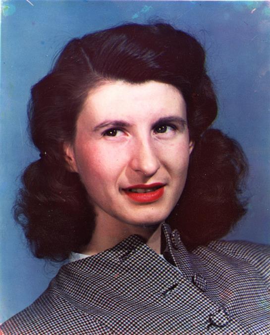 A fashionable woman smiles confidently, showcasing her elegant hairstyle and bold lip color.