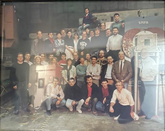 Workers gather to celebrate project completion, smiling and posing inside the factory setting.