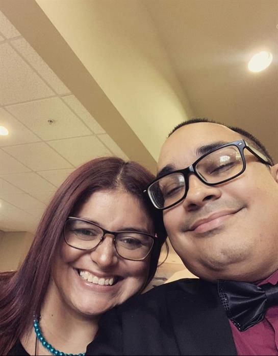 Couple enjoys a happy moment together, smiling while celebrating in a vibrant indoor setting.