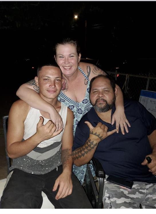 Three friends share smiles and laughter during a relaxed night out by the beach, creating memories.