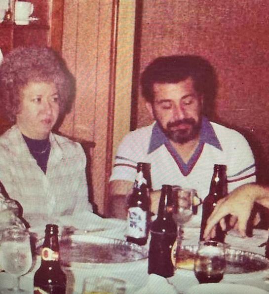 People enjoy an evening together, sharing drinks and engaging in conversation at a dinner table.