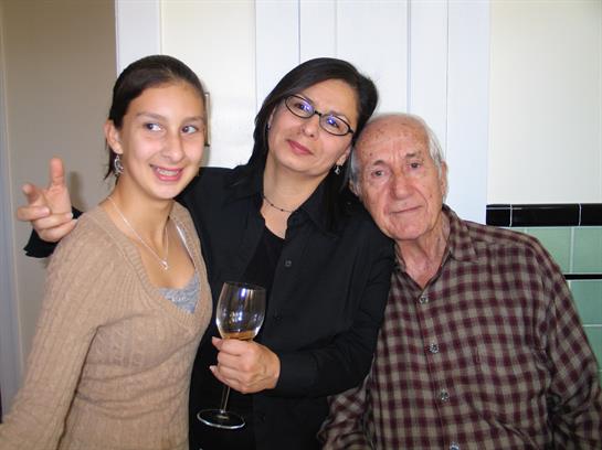 A girl, woman, and elderly man smile together, highlighting strong family bonds.