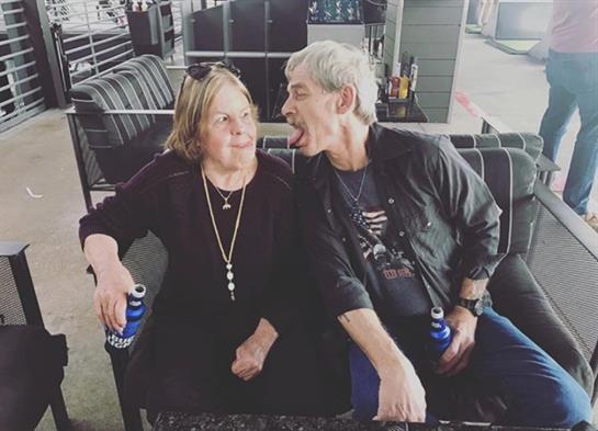 Two people share a playful moment together while seated in a lounge.