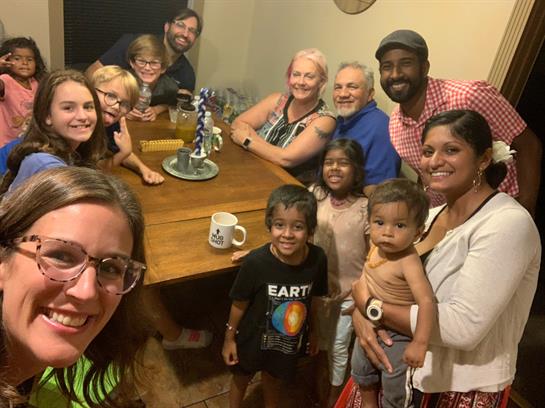 Group of excited people celebrating together at a table, enjoying each other's company.