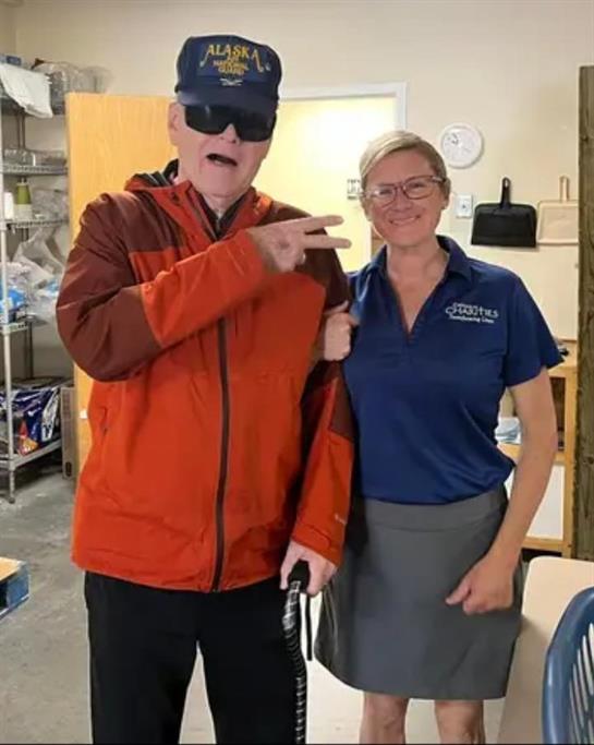 A man wearing sunglasses and a hat with a woman standing in a room