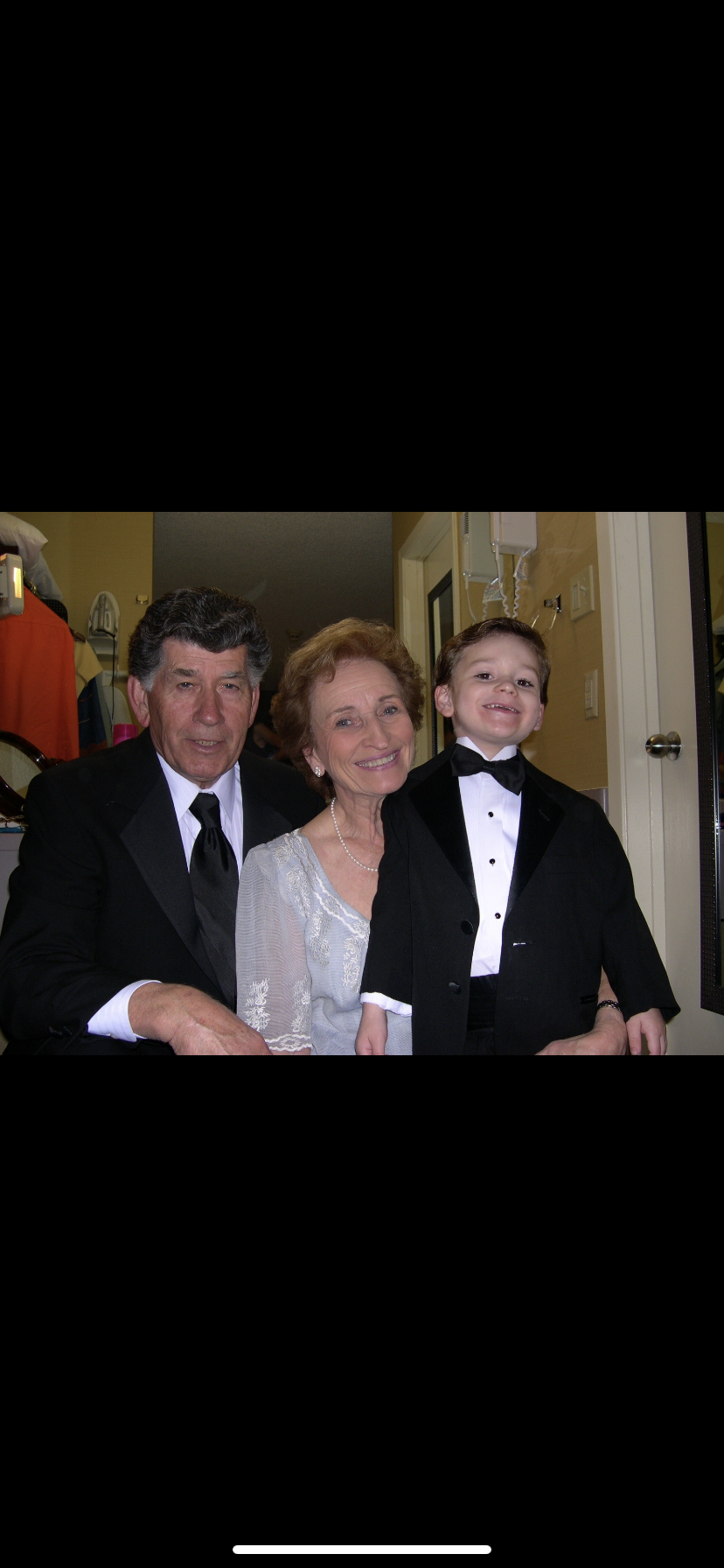 A couple and their son pose happily in formal wear, celebrating a special occasion together.