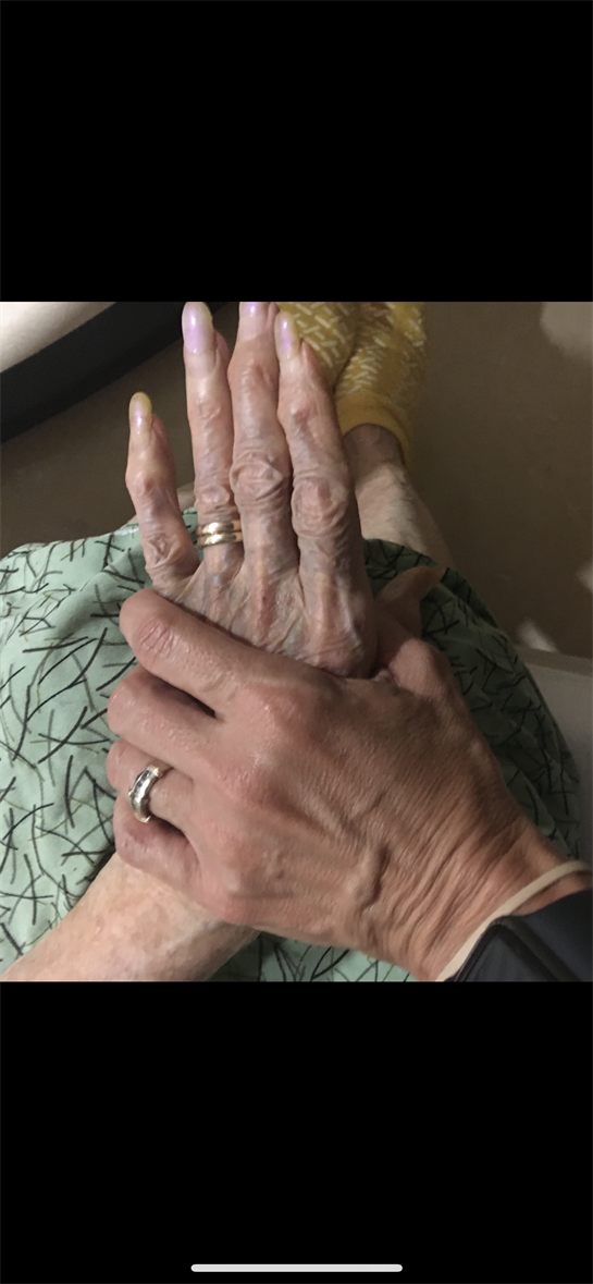 Two hands, one aged and wrinkled, the other younger and strong, express a bond of love.