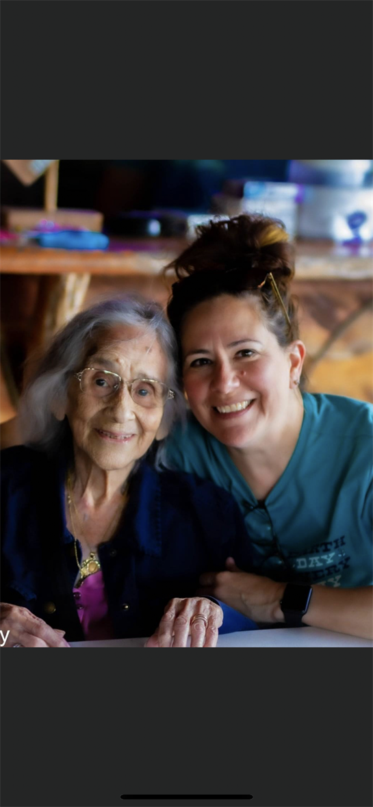 A woman and her elderly mother share a heartfelt moment in a warm, inviting setting.