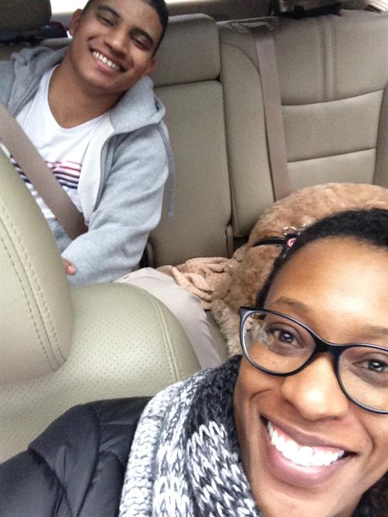 A mother and her child are smiling while traveling in a car, creating a joyful atmosphere.