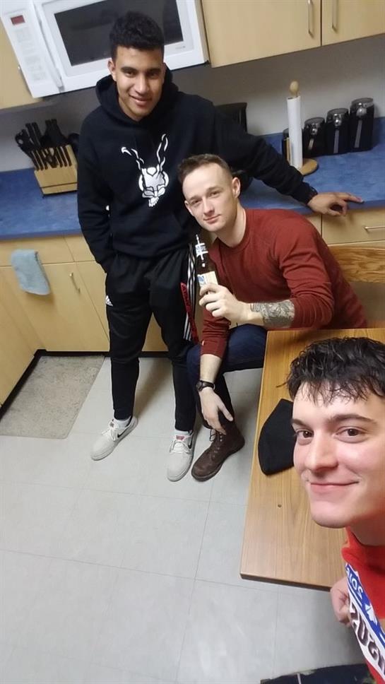 Three friends gather around a table, sharing laughs and drinks in a relaxed atmosphere.