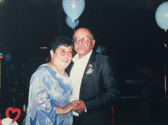 Elderly couple dances together while enjoying a special occasion with lovely decorations around.