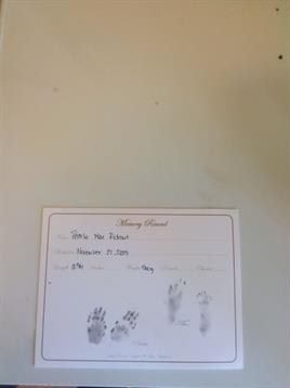 A keepsake paper displays small handprints of a baby, highlighting a cherished memory.