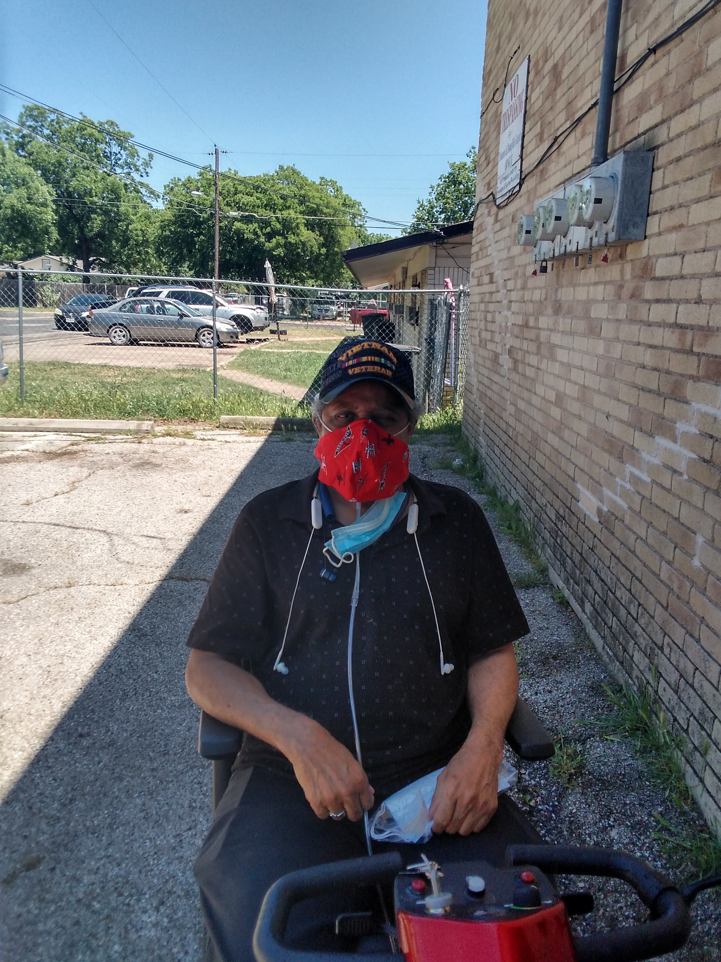 A man sitting on a bench wearing a face mask