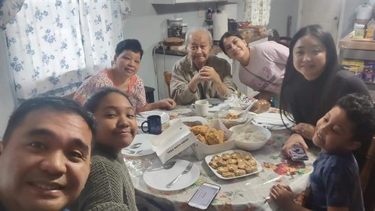 A group of people sitting around a table with food