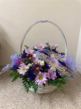 A basket of flowers with ribbon