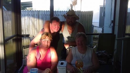 Friends celebrate together on a warm evening, sharing smiles and drinks in a cozy setting.