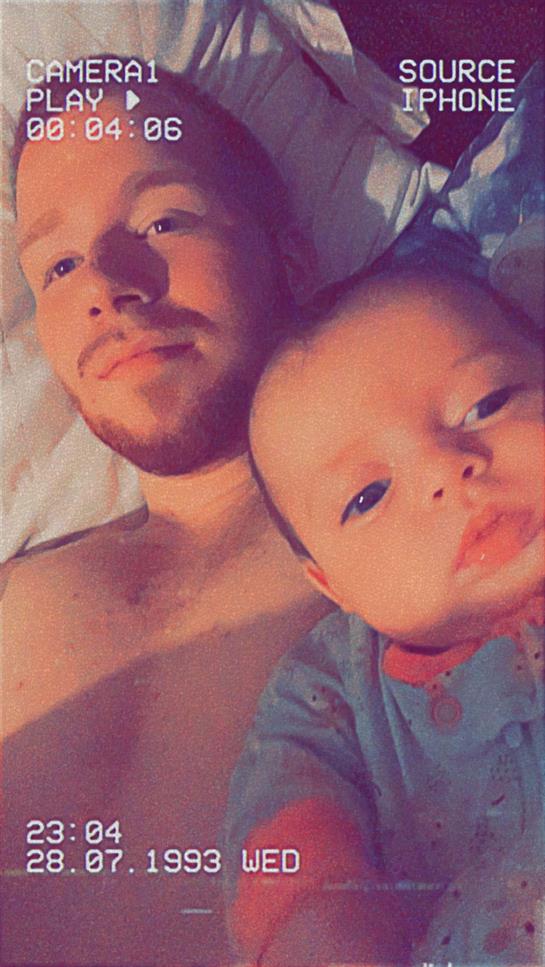 A father cuddles with his baby in bed, enjoying a peaceful morning together in their home.