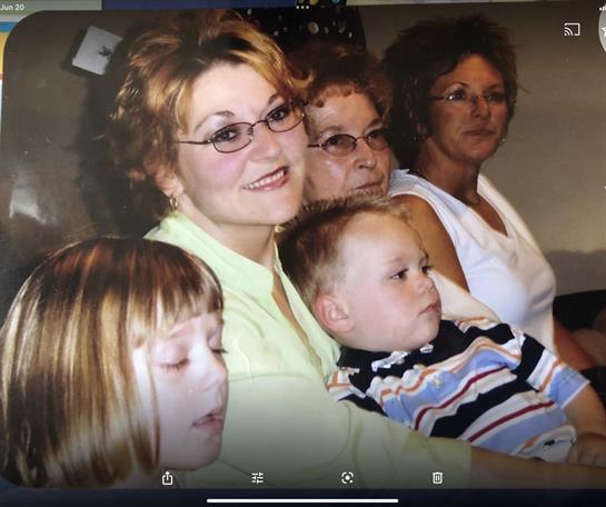 Adults and children share smiles and laughter during a relaxed family gathering indoors.