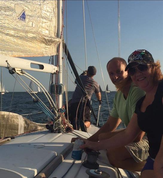 Crew members sail together on calm waters, enjoying each other's company under the sun.