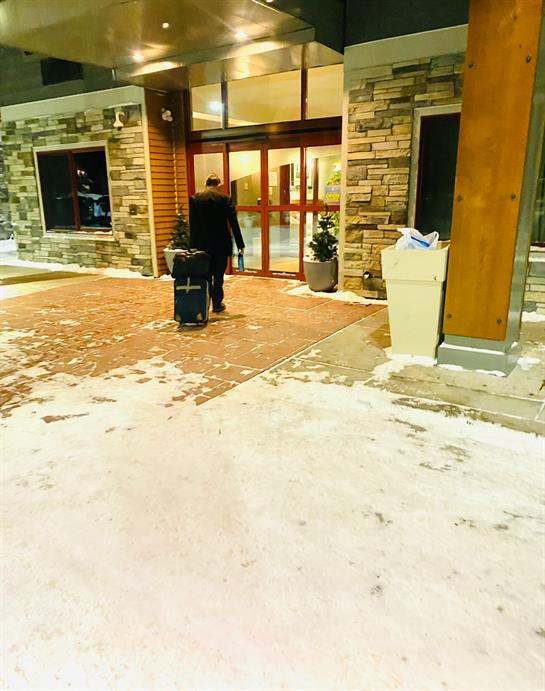 A person pulling luggage outside of a building