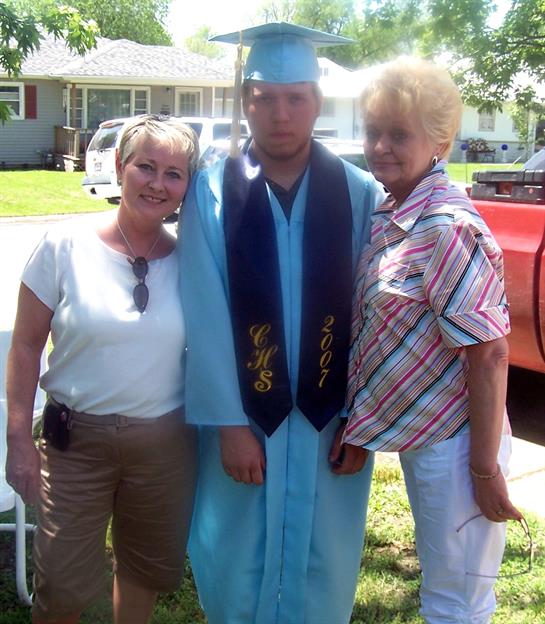 A man in a graduation cap and gown posing with a woman