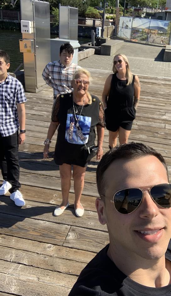 Friends gather for a fun day under the sun on a wooden pier, capturing memorable moments together.