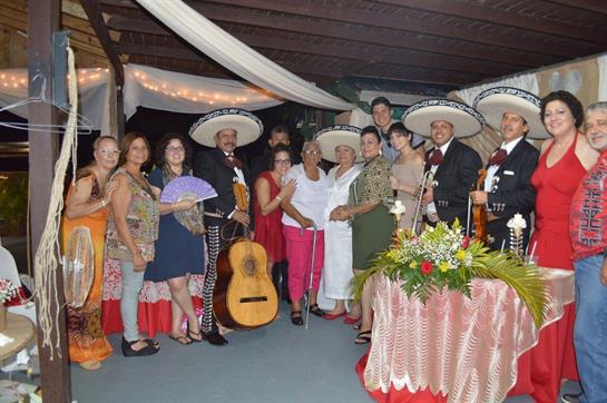 Friends gather to celebrate a special occasion, enjoying music and traditional Mexican culture.