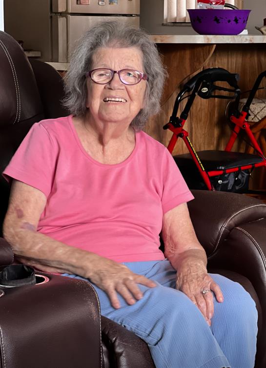 Senior woman enjoys her time in a cozy chair at home, radiating happiness and comfort.