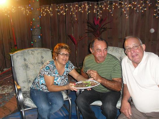 Friends enjoyed a meal together in a cozy space with twinkling lights and decorations.
