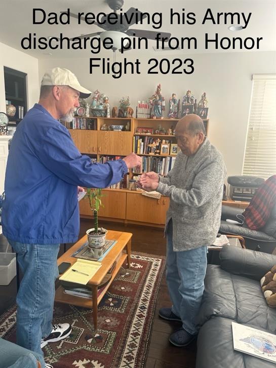 Two veterans engage in a meaningful discharge pin presentation at a local gathering in 2023.